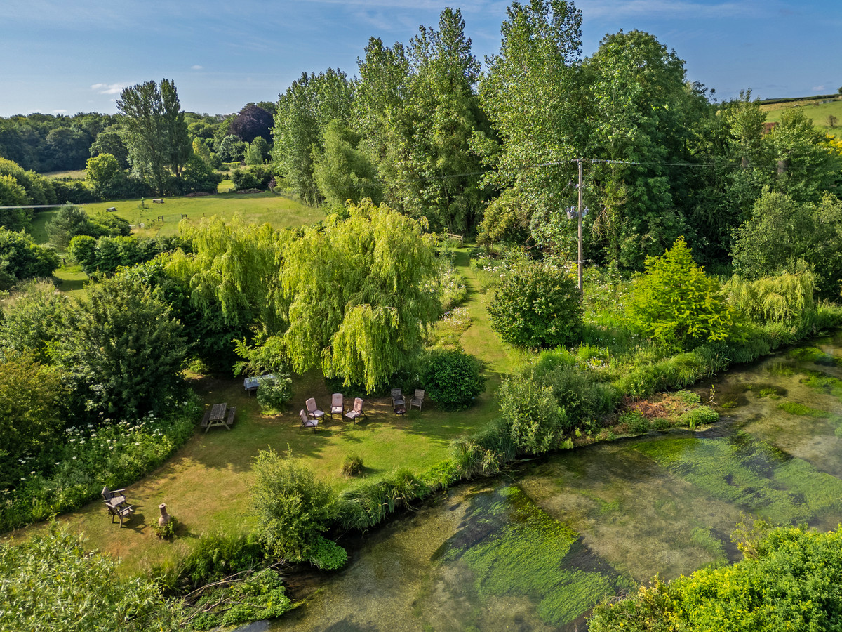 A stunning newly refurbished 4 bedroom barn with river frontage on approximately 5 and half acres in the lovely village of Tu